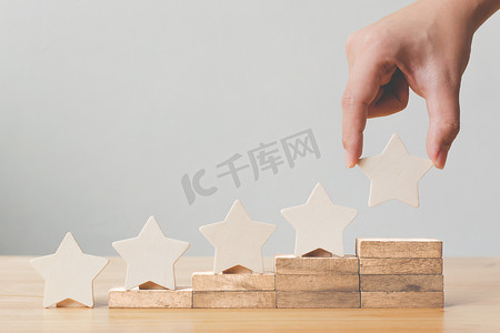 手把五星级木制的形状放在桌上.最佳优秀业务服务评价客户体验概念
