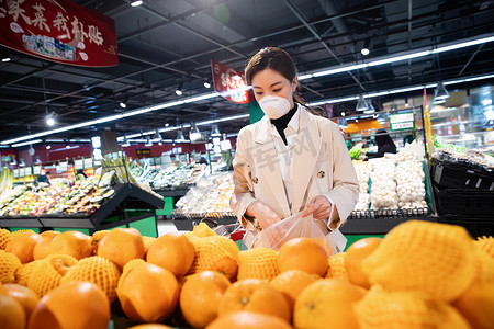水果超市促销摄影照片_戴口罩的青年女人在超市购买水果