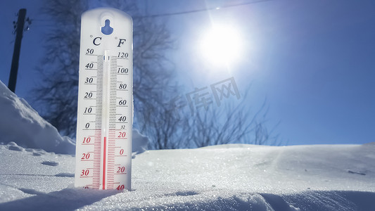 weather摄影照片_Thermometer in winter in the cold on snow and analyzes low negative air temperatures in clear sunny weather.Meteorological conditions and environmental analysis.Climate change on earth.Northern region