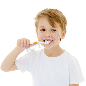 刷牙摄影照片_一个小男孩正在用牙刷刷牙.