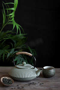 茶道摄影照片_在黑色背景上的茶壶和茶杯, 复制空间。传统的亚洲安排茶道-铁茶和陶瓷茶杯与茶.
