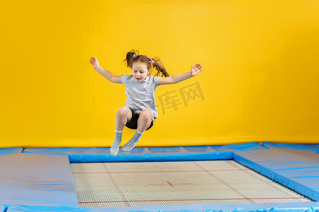 快乐的小女孩在健身中心跳蹦床