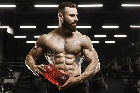 英俊强壮的运动肌肉男人喝水和运动营养