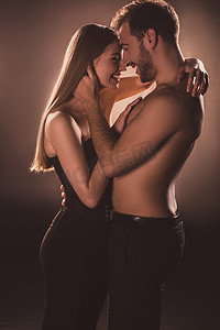 褐色药汤摄影照片_感性的情侣笑着拥抱在一起, 在褐色与背部光