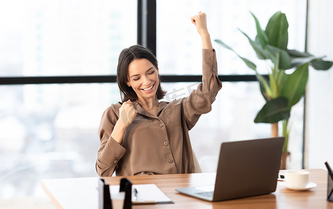 raising摄影照片_Ecstatic girl found new good idea raising her clenched fists