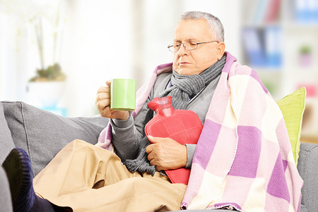 老人病摄影照片_坏人在沙发上，喝热茶
