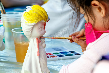 箭头围城一个圆摄影照片_女孩在街上画一个白色娃娃的油漆娃娃