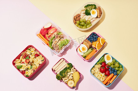 营养餐摄影照片_粉红背景的各类健康营养餐学校午餐盒的顶级观景模式