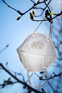 医疗防护口罩摄影照片_悬挂在树枝上的口罩