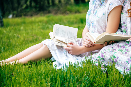 年轻女子在夏天拿着和读一本书的特写