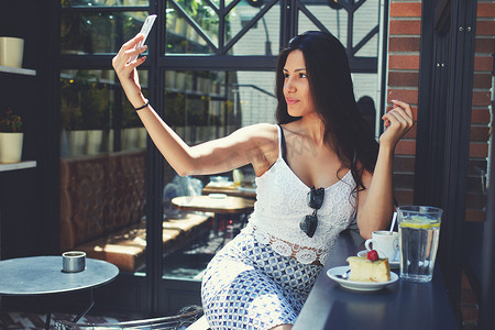 Woman making self portrait with mobile phone