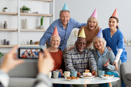 积极的老年人和护士庆祝生日，拍照