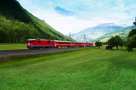 山谷摄影照片_火车穿越阿尔卑斯山附近的平原绿色山谷