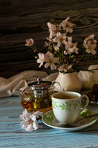 实用的小摄影照片_质朴的静物。实用, 热草药茶, 糖果和开花的杏仁小树枝在一个木桌特写