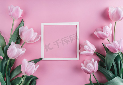 郁金香花摄影照片_粉红色的郁金香花和纸在淡粉色背景。圣情人节框架或背景。贺卡或婚礼请柬。平躺, 顶部视图, 复制空间