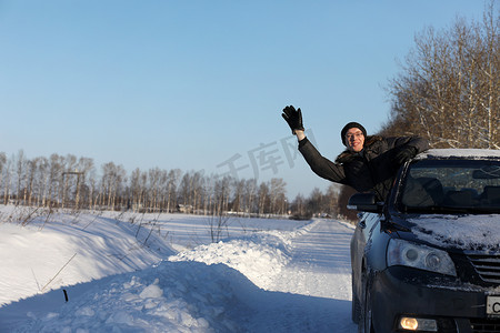 男人看着窗外白雪覆盖的道路上的车窗