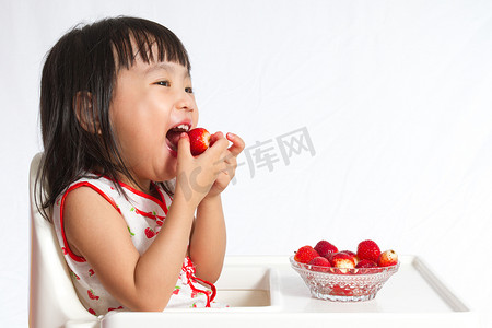 亚洲的中国小女孩吃草莓