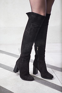 皮靴摄影照片_在高的黑色靴子，女孩。图册，妇女高制造的皮靴