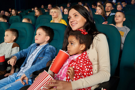 看电影弹窗摄影照片_儿童与父母正一起在电影院看电影