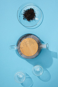 鲜茶壶、空杯、干凉茶在蓝碗中的顶部视图 