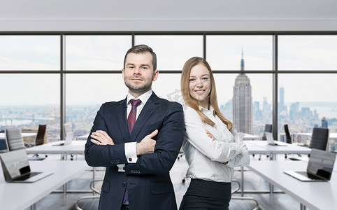 Couple of young managers are standing in the modern panoramic office. New York, Manhattan panoramic view.