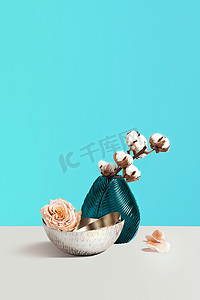 创意构图与花瓶, 花和装饰棉在灰色的桌子上对蓝色背景与空间的设计。花店概念。简约装饰