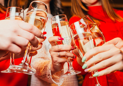 一群女性朋友用香槟酒杯庆祝和叮当作响 