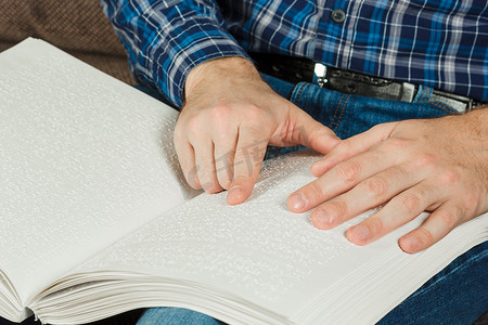 盲人正在读一本盲文书。触摸你 