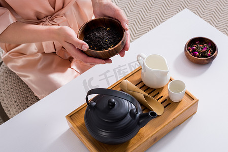 拿着照片摄影照片_在家里早上手里拿着红茶的女人手持木碗的裁剪照片