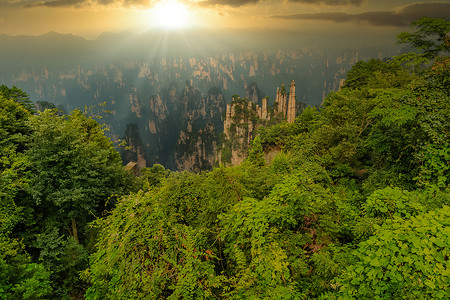 阳光山脉摄影照片_第一缕阳光。中国张家界国家森林公园张家界山脉下方升起的太阳