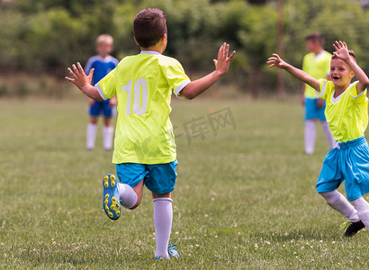 儿童足球足球-在胜利后拥抱中的小朋友们庆祝