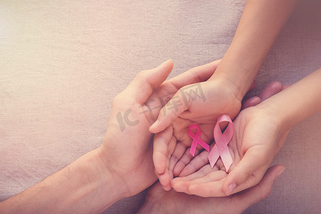 坚定四个意识摄影照片_成人和儿童手持有粉红色丝带, 乳腺癌意识, 腹部癌症意识, 10月粉红色概念 