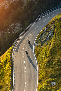 摩托车摄影照片_在高山公路骑的摩托车驾驶员。户外摄影