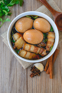 猪肉炖煮摄影照片_鸡蛋和猪肉的赤褐色的酱汁，泰国菜，炖蛋