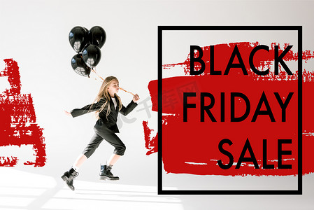 时尚的孩子在时尚的西装跳跃与黑色气球灰色, 黑色星期五销售横幅概念