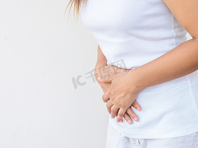 年轻美丽的女人有痛苦的胃痛在白色的背景。慢性胃炎。腹部腹胀概念.