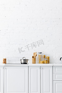 简约的现代白色厨房内部，墙壁附近有厨房用具和食物