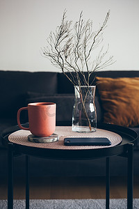 现代内部细节。小圆桌,用陶瓷红色的茶杯,配上美味的伯爵茶.下班后在家休息，离线休息。有选择的重点。垂直照片