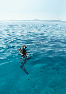 在克罗地亚亚得里亚海表面的潜水员。打得很长地平线以上的水. 