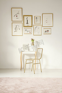 金色的椅子由一个优雅的虚荣表与镜子由白色的墙壁与图画画廊在女性卧室内部与粉红色的地毯