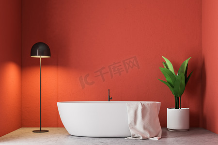 简约红色浴室内有一个白色浴缸, 一条毛巾挂在上面, 一棵盆栽树和一盏灯在角落里。3d 渲染模拟