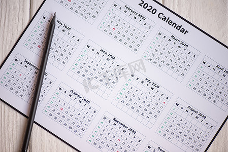 2020图摄影照片_木制背景图上2020年日历和铅笔的顶视图
