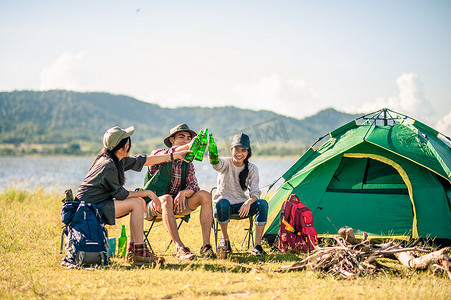 冒险岛壁纸站摄影照片_ 一群游客在露营时碰碰啤酒瓶。冒险、旅游、旅游、友谊和人的观念.