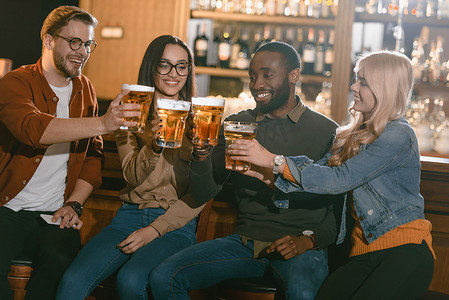 愉快的多元朋友一起喝啤酒在酒吧  