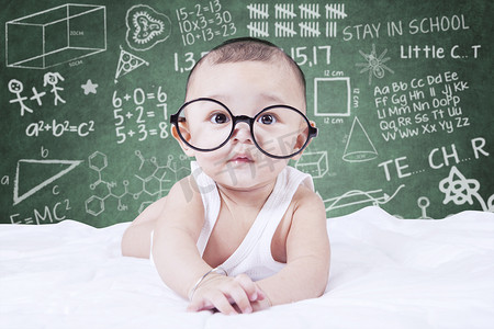and摄影照片_Funny baby with glasses and a doodles background