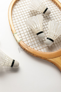 木制羽毛球拍和白色背景上的穿梭球拍的特写视图