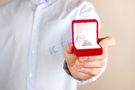 结婚金色摄影照片_订婚/结婚/求婚场面。把昂贵的金色白金钻石戒指交给他的新娘.