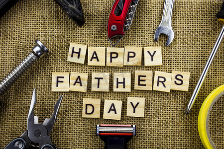 快乐的父亲日消息在粗麻布黄麻背景与工具和领带框架.