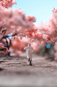 粉色温馨小清新摄影照片_樱花树下的医护人员奔跑的背影