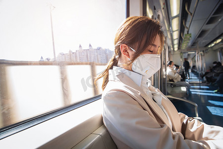 年轻女人戴口罩坐地铁